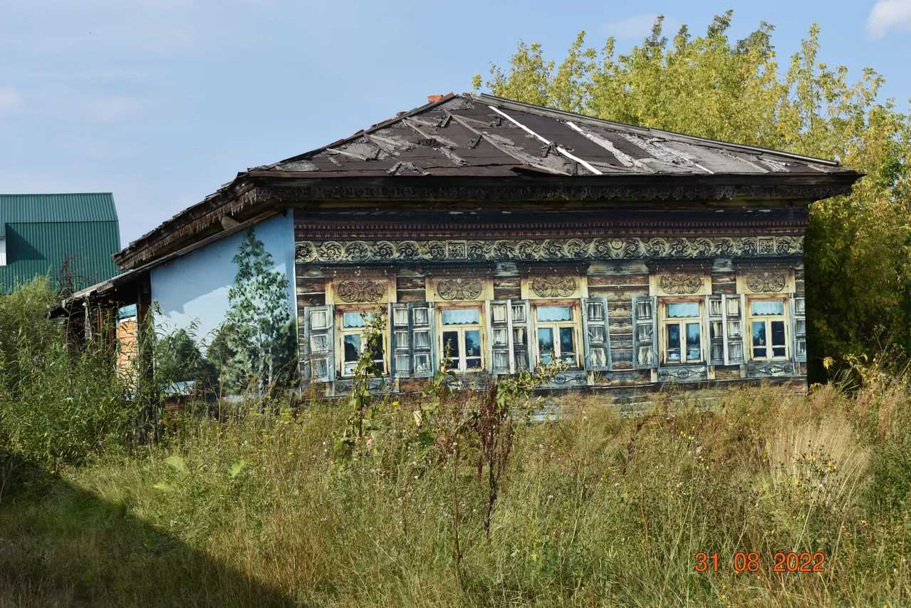 Деревянный жилой дом конца XIX века с глухой и пропильной резьбой карнизов, наличников и воротами с оригинальным декором «солнышко»
